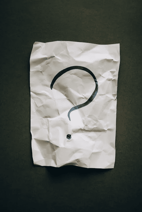 A crumpled up piece of paper with a question mark. 