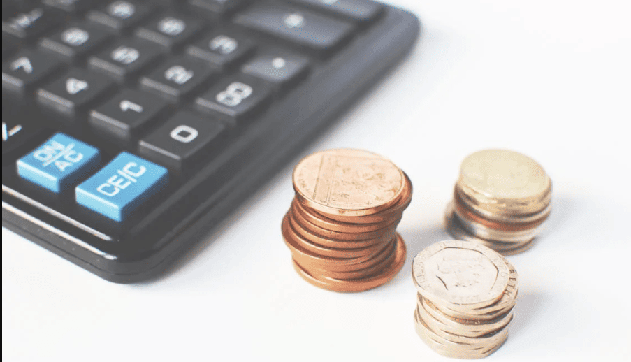 Coins alongside a calculator. 