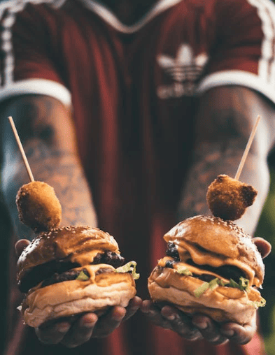 Egy személy két hamburgert tart a kezében