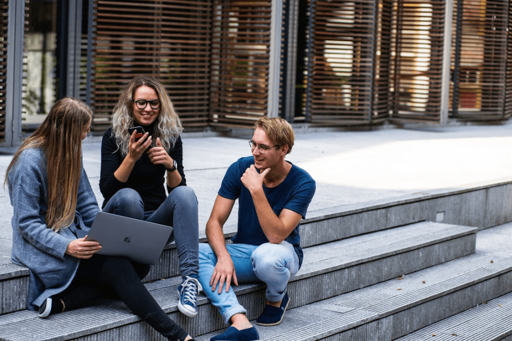 Students sitting on stairs and talking to each other. 