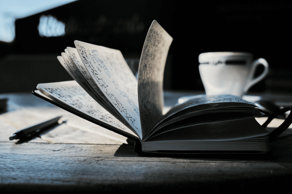 An open book on a brown wooden table.