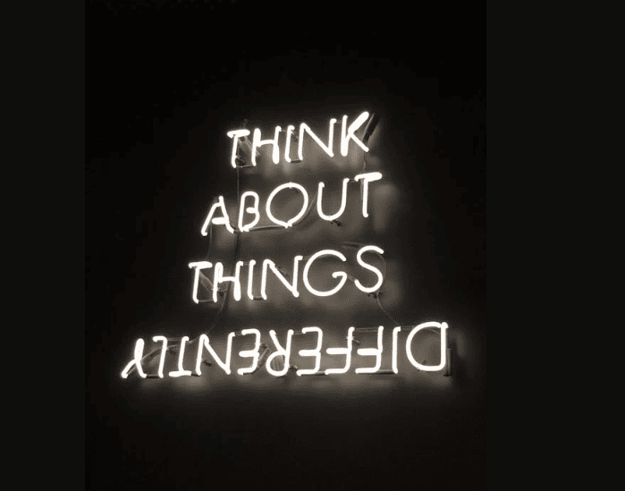 A neon sign that says "Think about things differently."