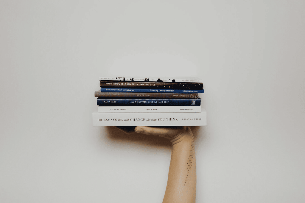 A person holding a pile of books.