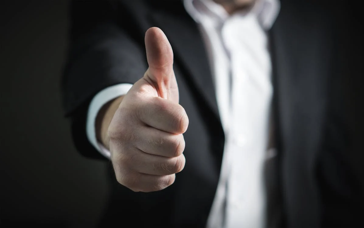 A close up of a hand showing a thumbs up.