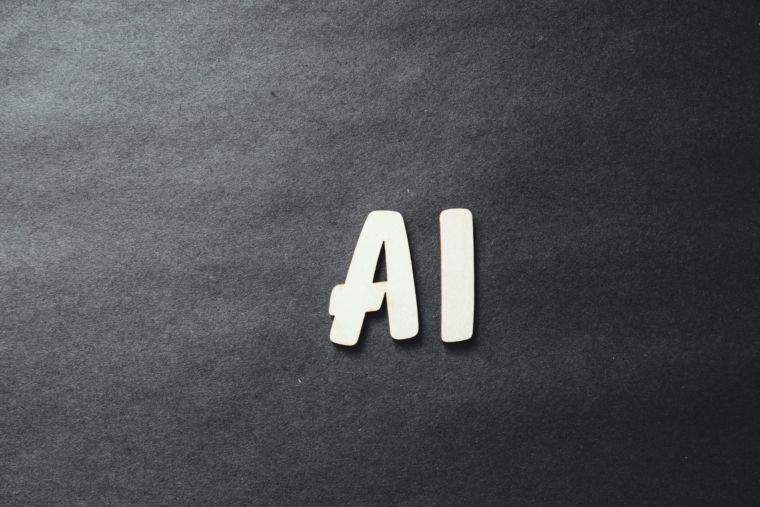 The word "AI" spelled in white letters on a black surface.