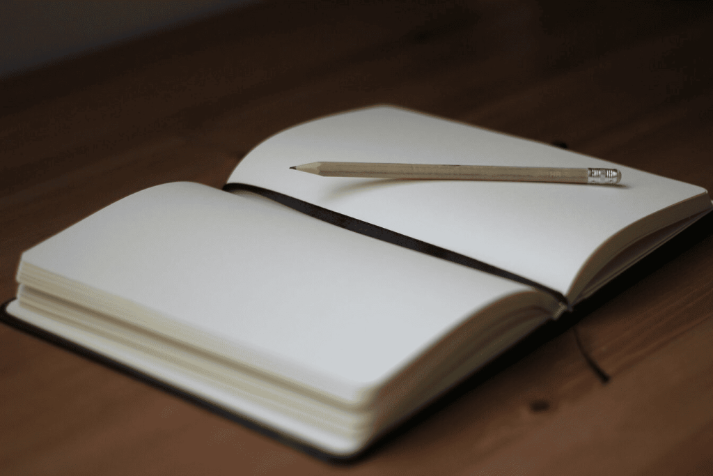 A brown pencil on top of a white book page.