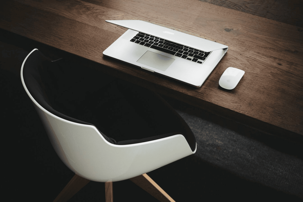 Apple MacBook beside a computer mouse on a table.