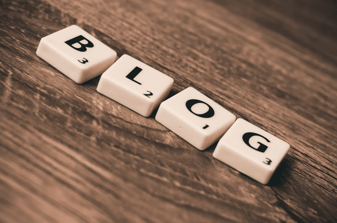 The word "blog" in titles on a wooden table. 