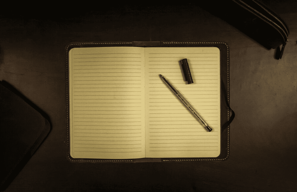 An open notebook with a pen inside it.