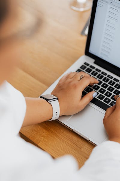 A person working on a laptop while composing an email in a clean, minimal inbox interface.