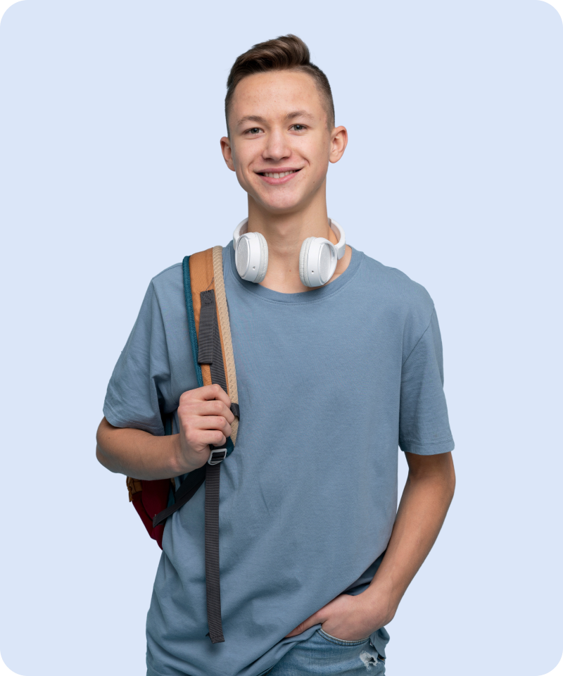 A smiling male student and Smodin customer with headphones around his neck and a backpack on one shoulder.