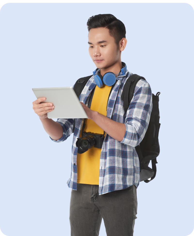 Male student wearing a backpack with headphones around his neck and using Smodin on his tablet device.